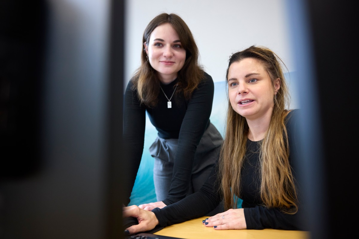 Two IQWiG employees look at a computer screen