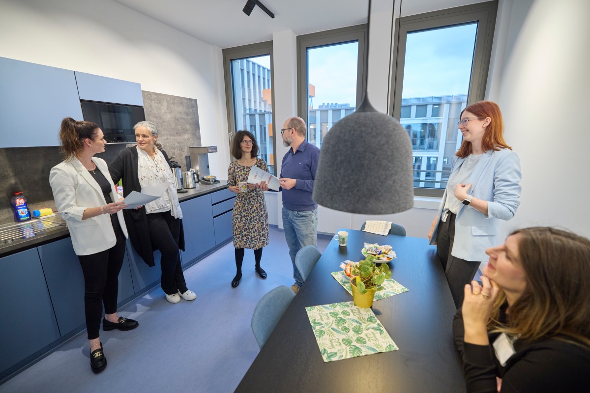 IQWiG employees chat in a blue kitchen