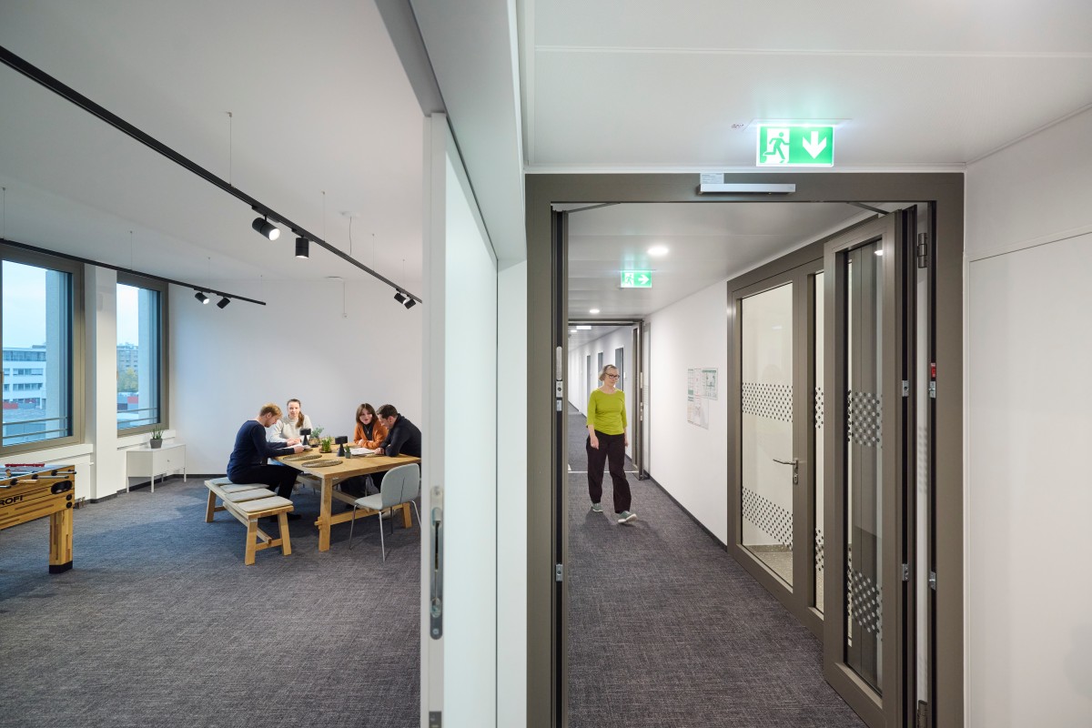 Split photo. In one half, IQWiG employees are sitting at a table, in the other half an IQWiG employee is walking through the corridor